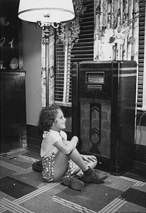 Photograph of a young girl listening to the ra...